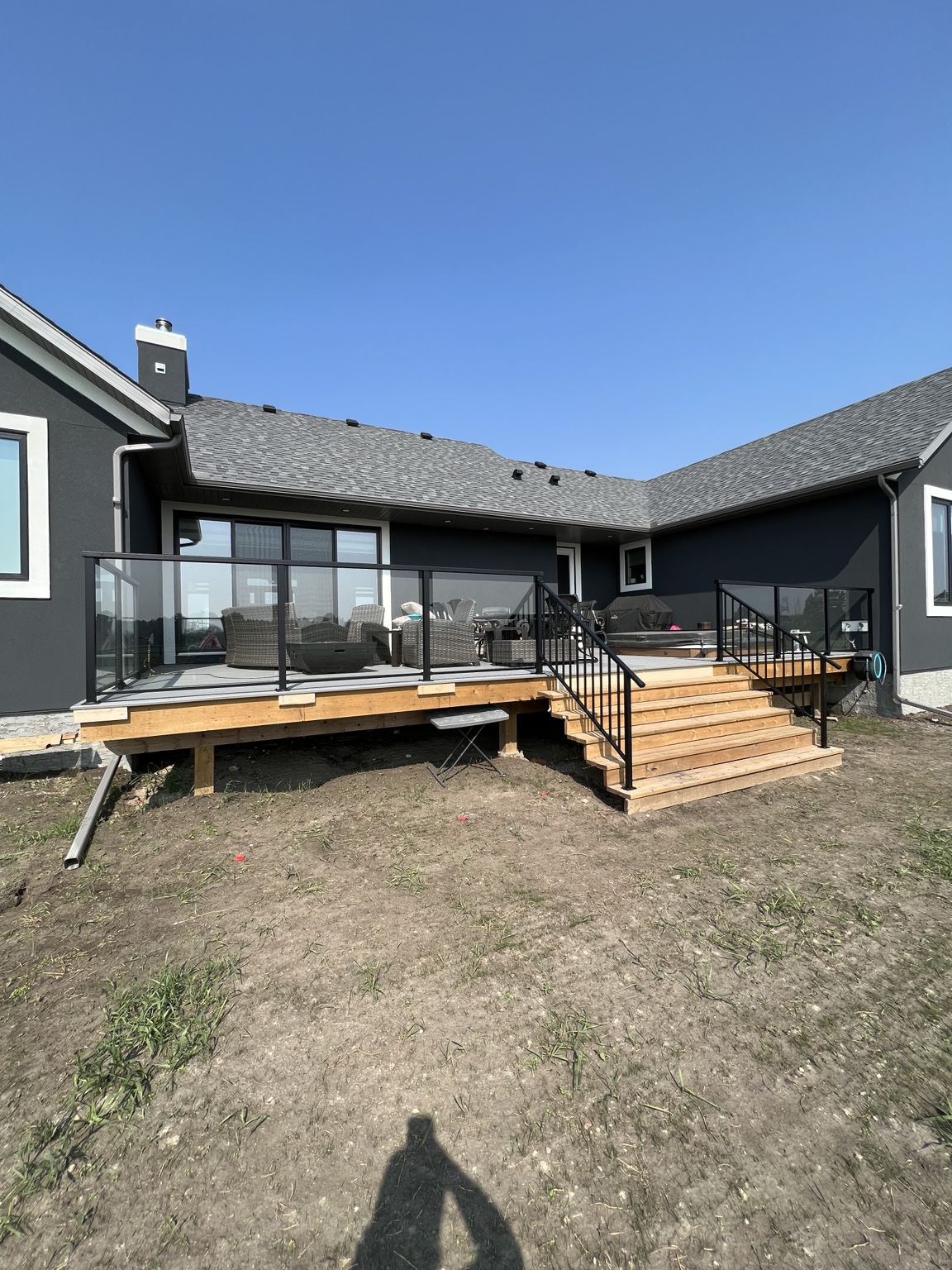Large backyard deck with black glass railing