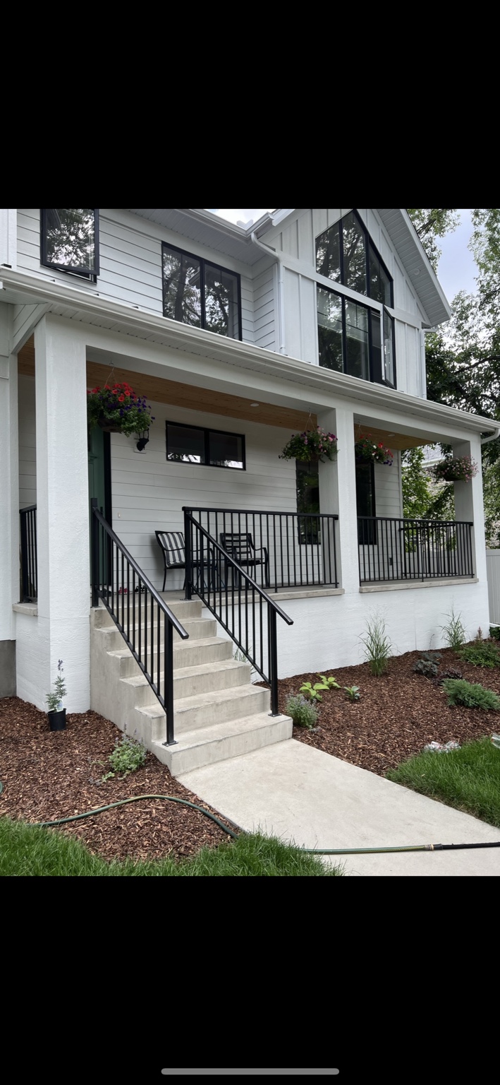 Black aluminum railing on a finished front entry and concrete steps