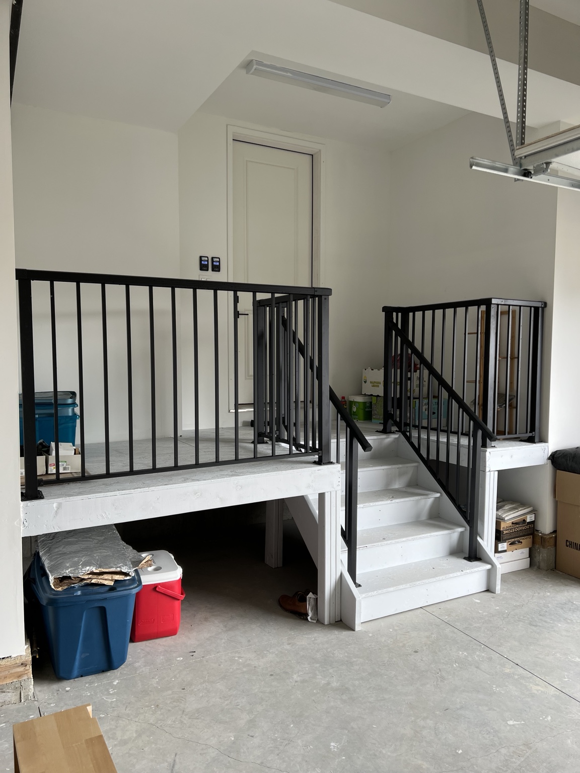 Black aluminum railing installed on garage stairs and landing
