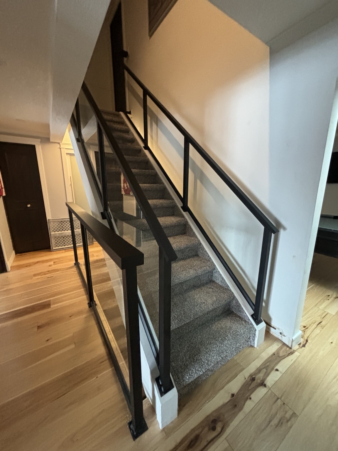 Modern black framed glass railing on an interior staircase