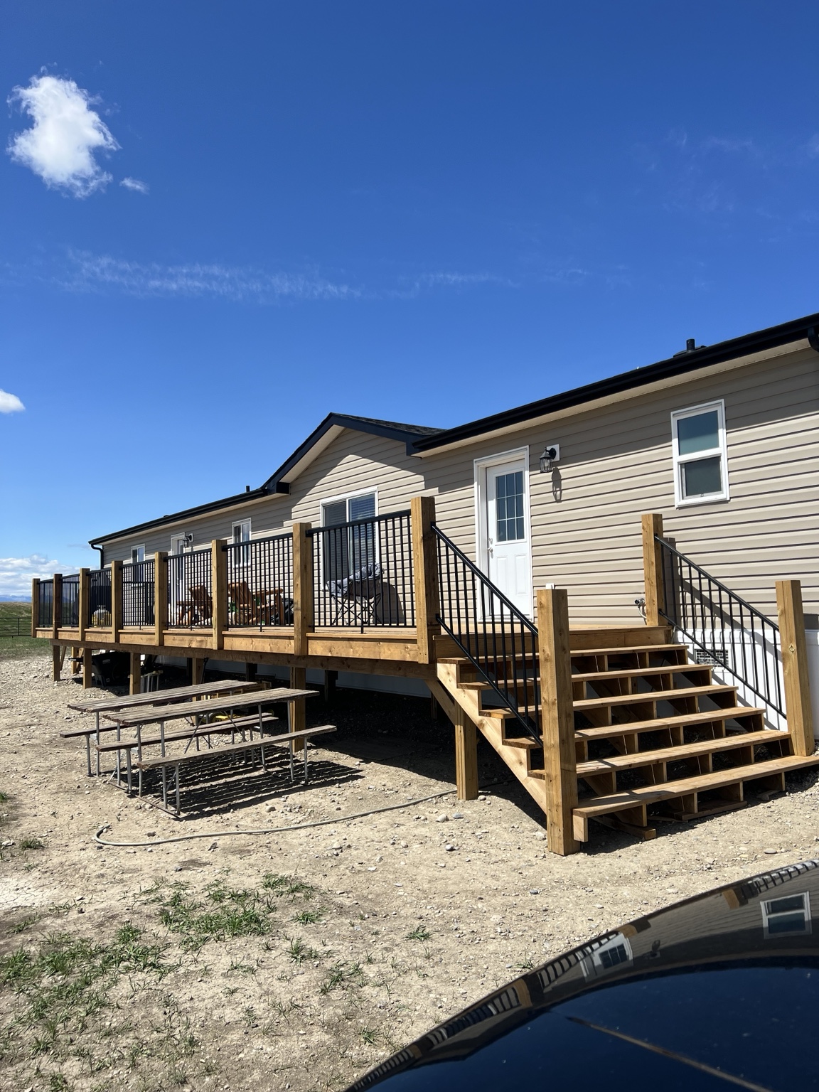 Large wood deck with black aluminum picket railing and stairs