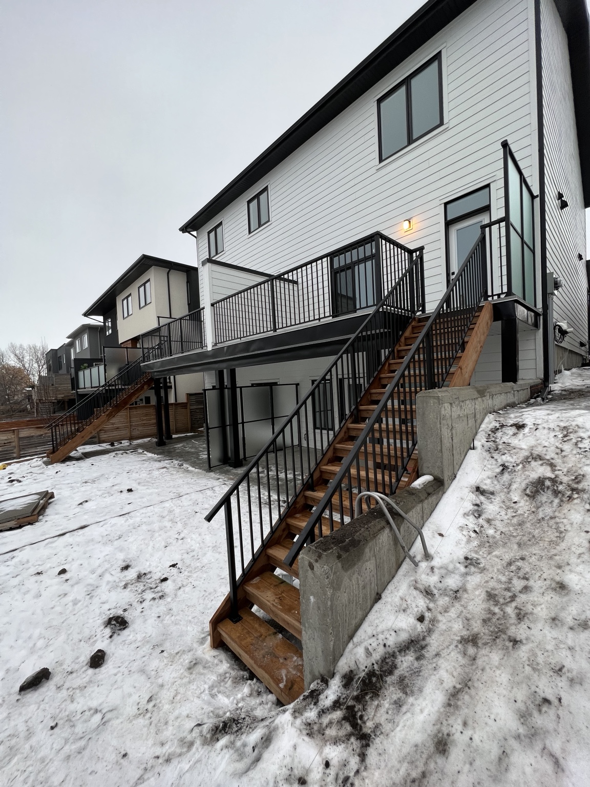 Large elevated deck with black aluminum railing and two stair runs