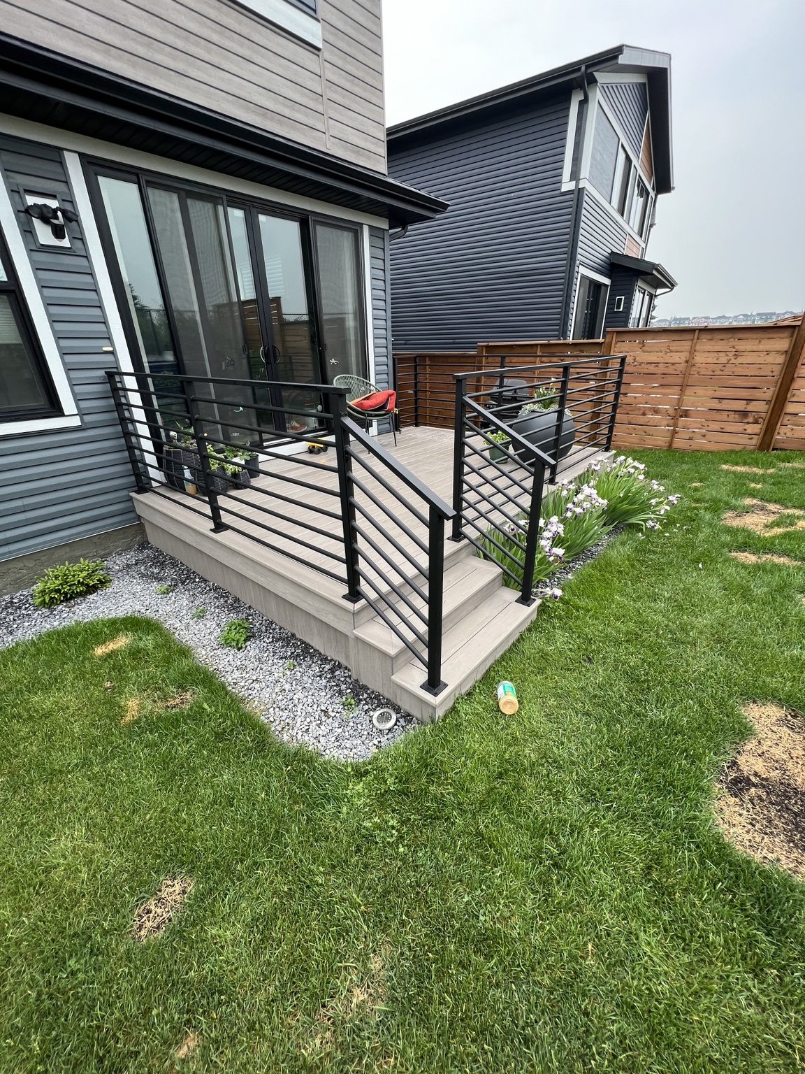 Modern backyard deck with black aluminum railing