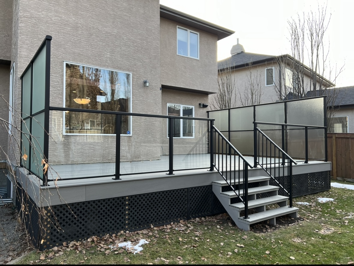 Finished backyard deck with black glass and privacy railing