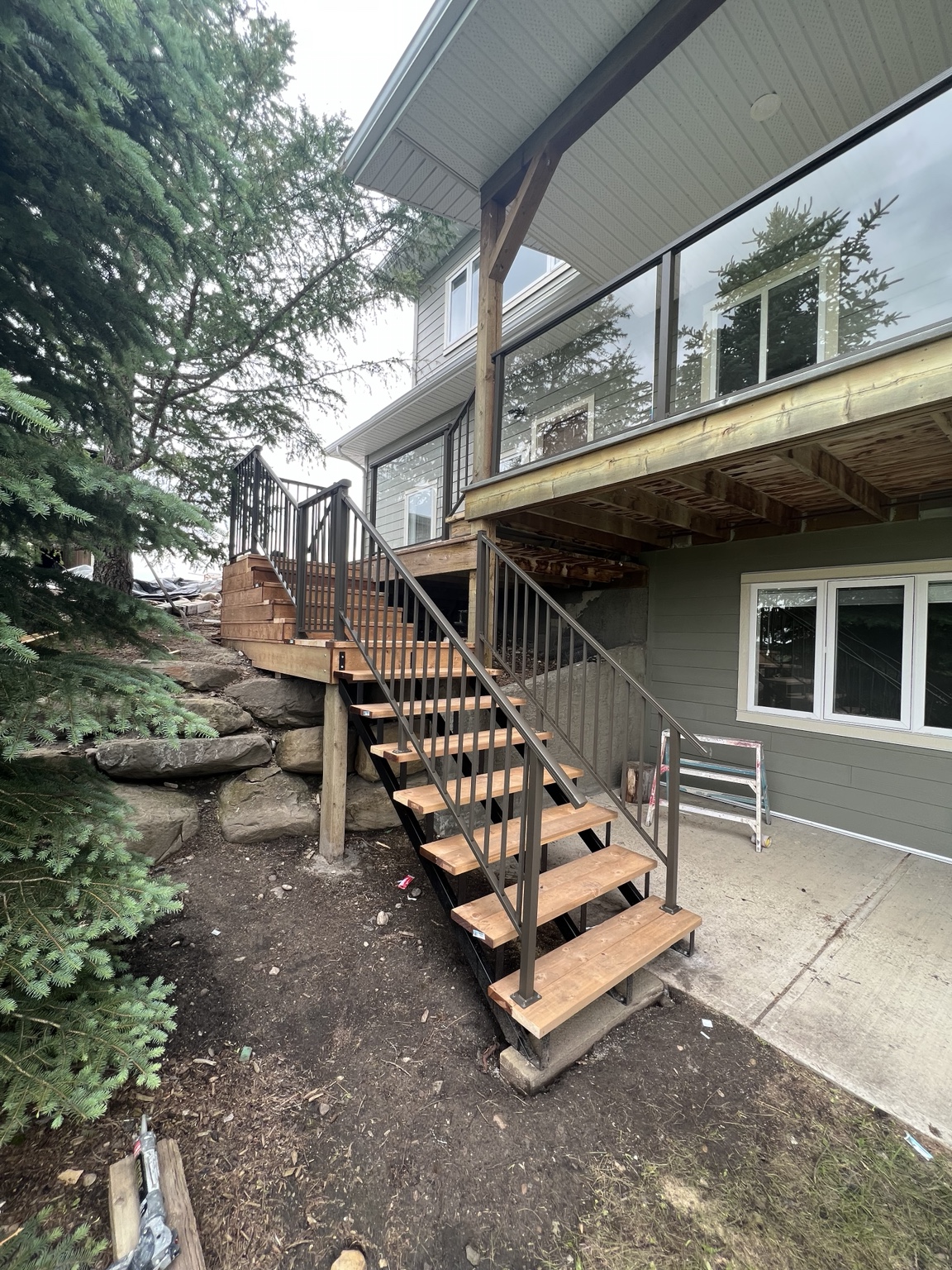 Raised wood deck with stairs and black aluminum railing