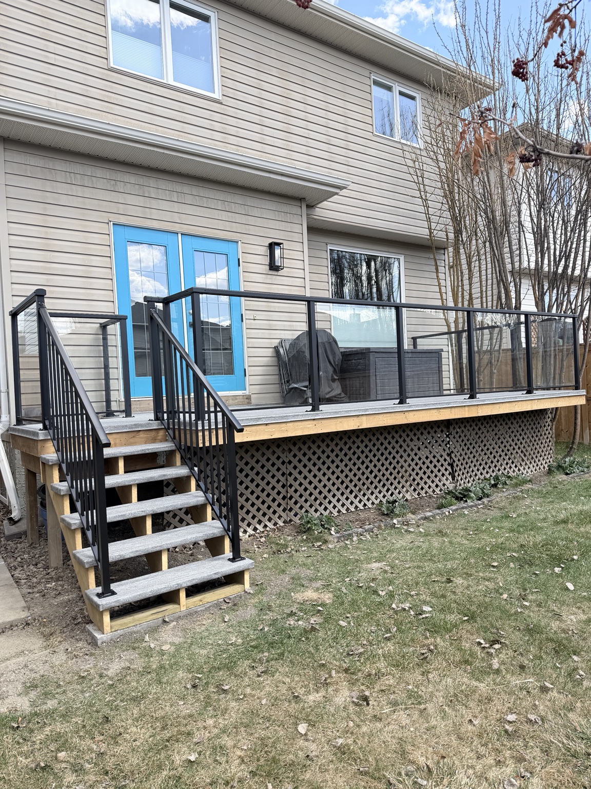 Renovated deck with waterproof vinyl and black glass railing
