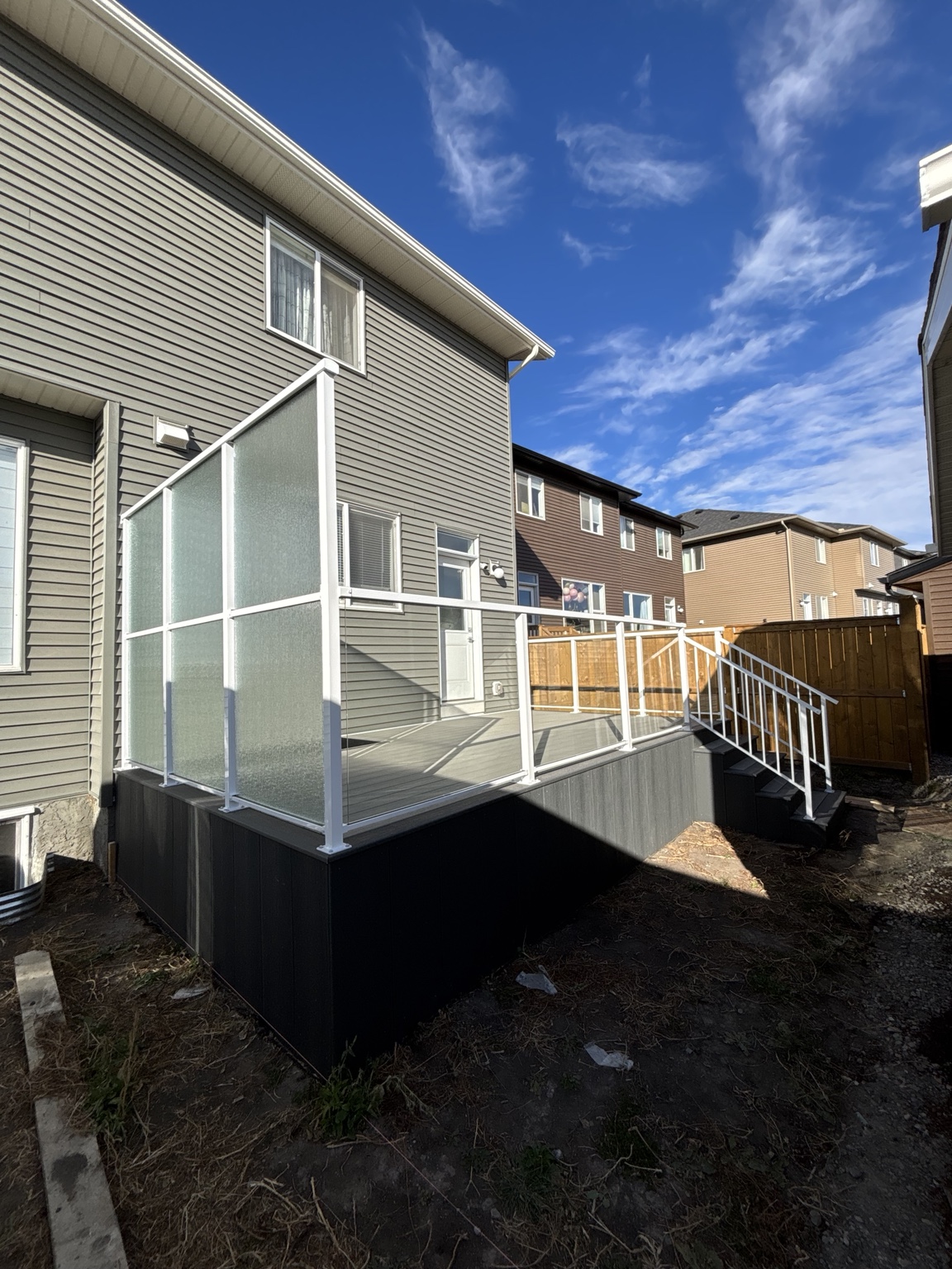 Grey waterproof vinyl deck with white powder-coated aluminum, clear glass, and privacy glass railing