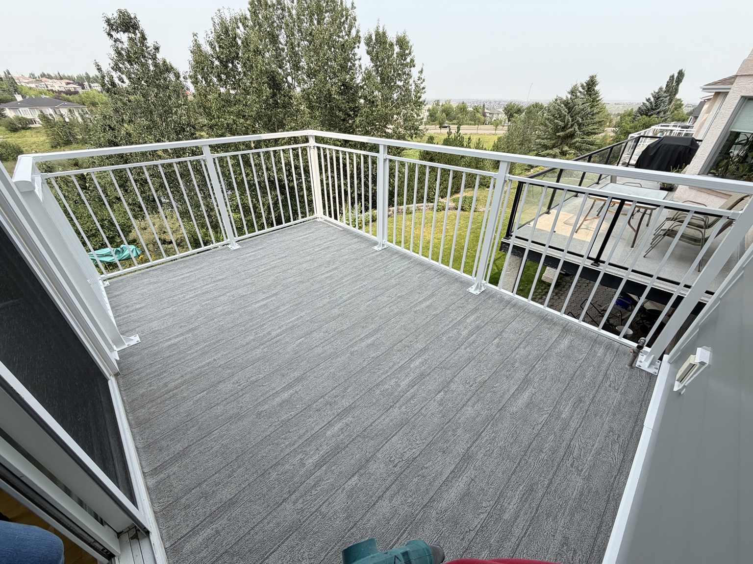 White railing surrounding a grey vinyl deck